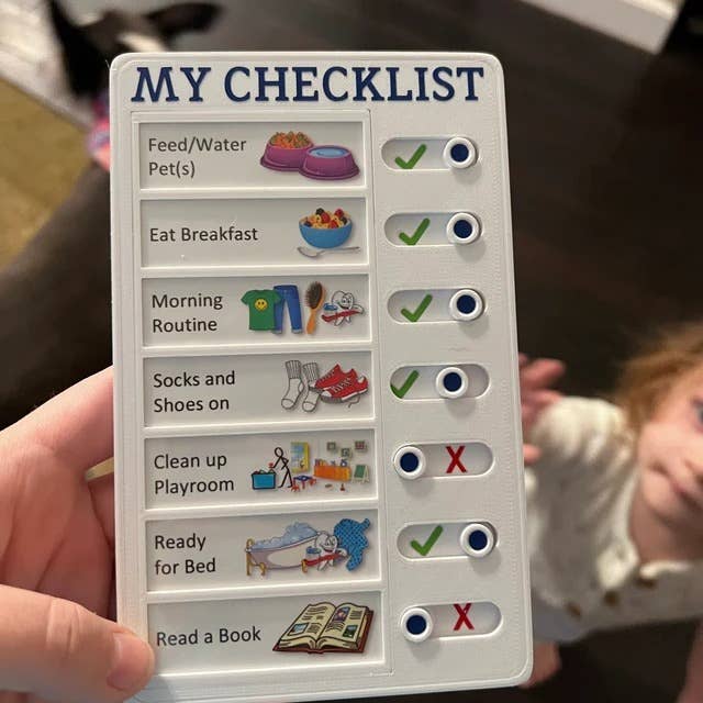 person holding the chore list with different chore labels and images