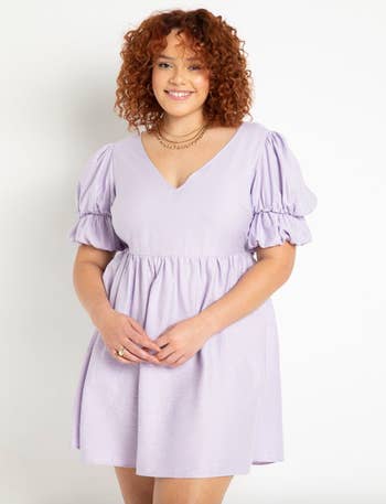 a model in a knee length lavender dress with double ruffled sleeves