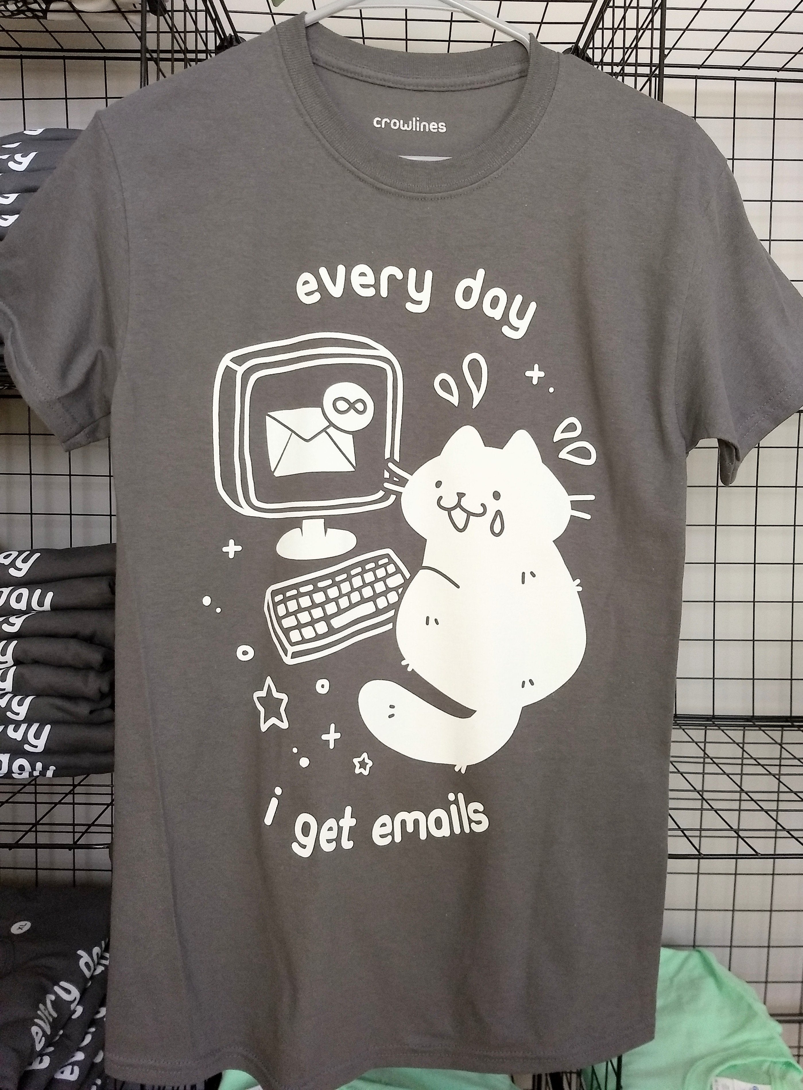 灰色短袖t形的白色图形以泪一只猫的脸上显示收件箱的笔记本电脑前无穷和文本
