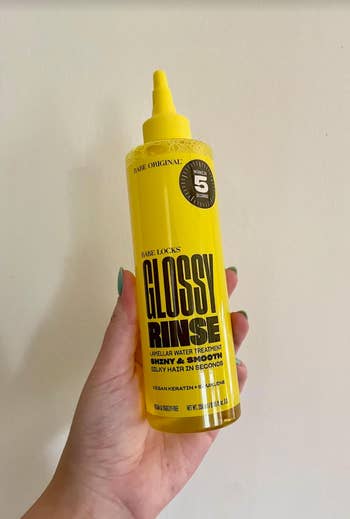 hand holding the bottle of glossy rinse