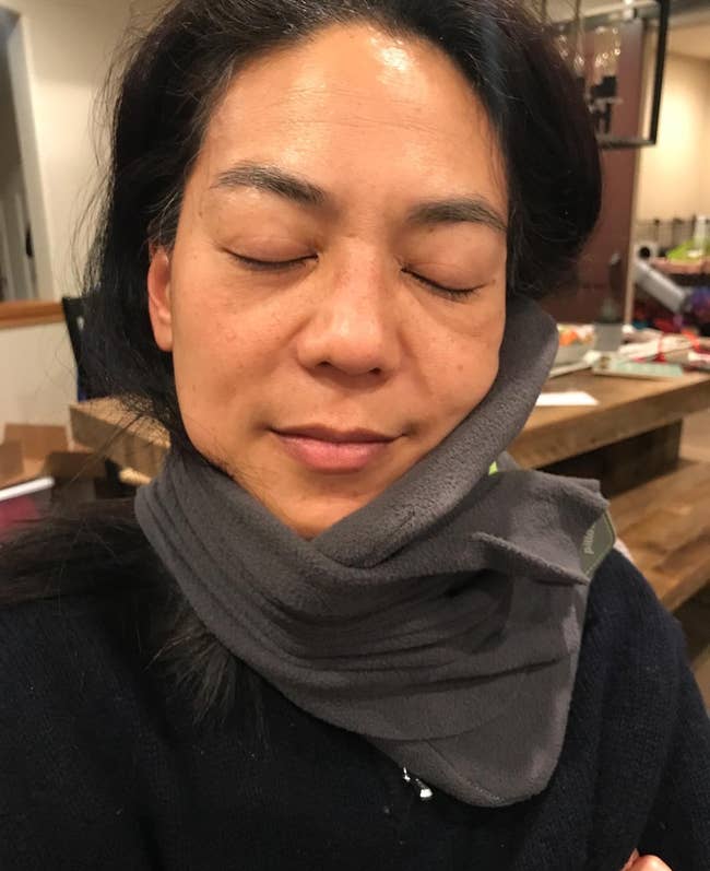 a reviewer wearing the travel pillow 