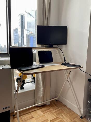 reviewer's desk with a monitor on the top tier and a laptop and tablet on the bottom tier