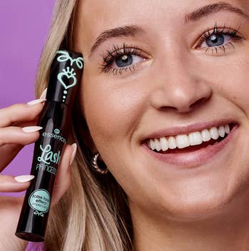 model holds tube of the Lash Princess mascara next to eyelashes that are lifted and have more volume thanks to the mascara