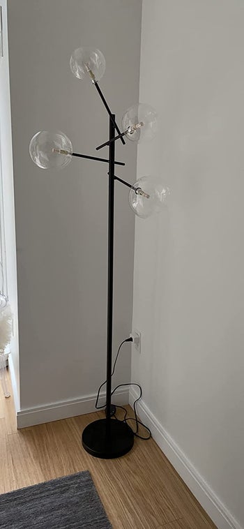 Reviewer image of product turned off and plugged in to corner of gray wall