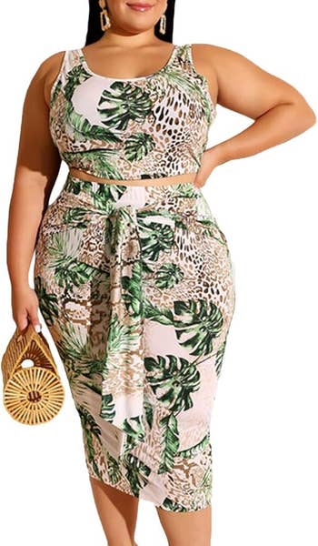 Woman in a tropical print crop top and skirt holding a bamboo purse, showcasing a stylish summer outfit
