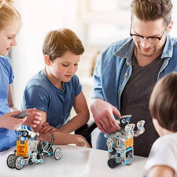Adult and child models playing with robot kit