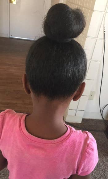 a reviewer showing their child's curly hair pulled up in a bun