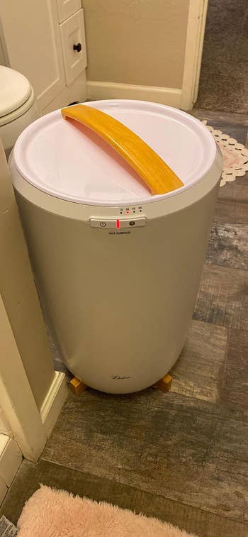 Compact top-loading washing instrumentality with a yellowish handle, suitable for tiny spaces oregon apartments