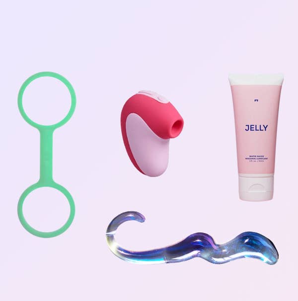 Green silicone cuffs, pink compact suction vibrator, pink bottle of Jelly lubricant and curvy glass dildo