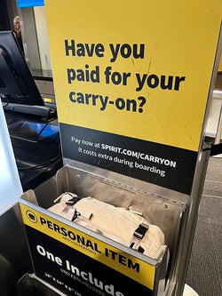 another reviewer's beige backpack in the personal item size checker at the airport