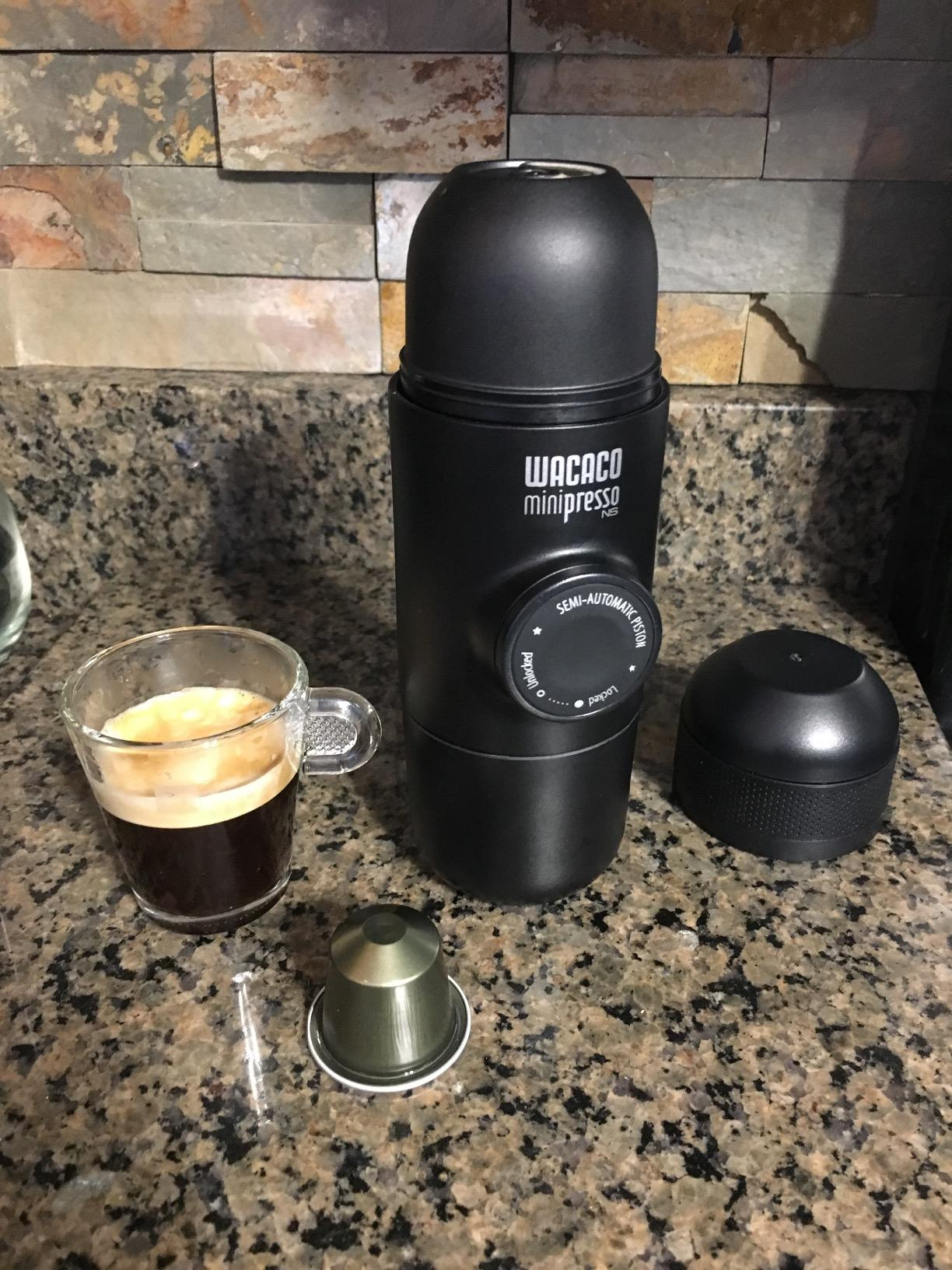 Lifestyle Transportable espresso maker with equipment and a freshly made espresso shot