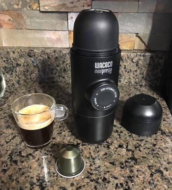 Lifestyle Transportable espresso maker with equipment and a freshly made espresso shot