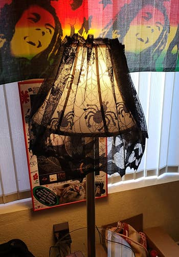 the spider web lampshade cover around a reviewer's  cone-shaped lamp