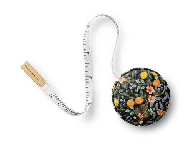 Floral-patterned measuring tape with a retractable design by Riley Blake Co., used for crafting or fashion projects
