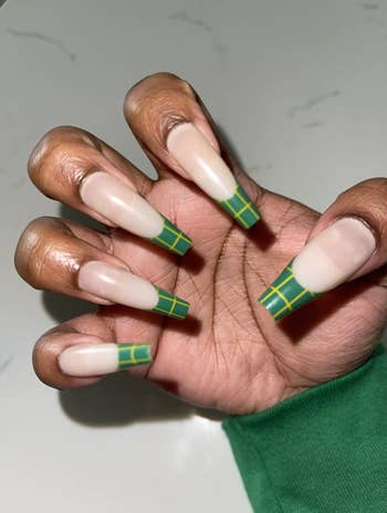 reviewer wearing long fake nails with green and yellow plaid print