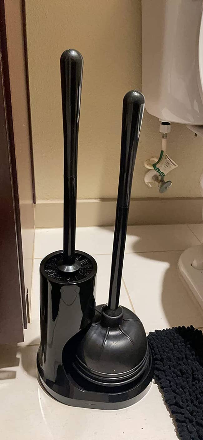 A reviewer's toilet plunger and brush in their bathroom