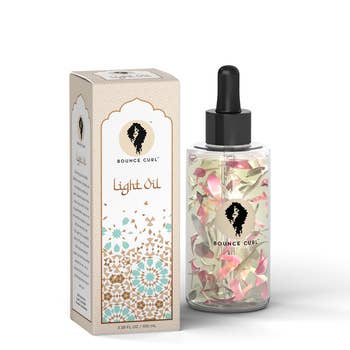 A light hair oil with petals inside the bottle
