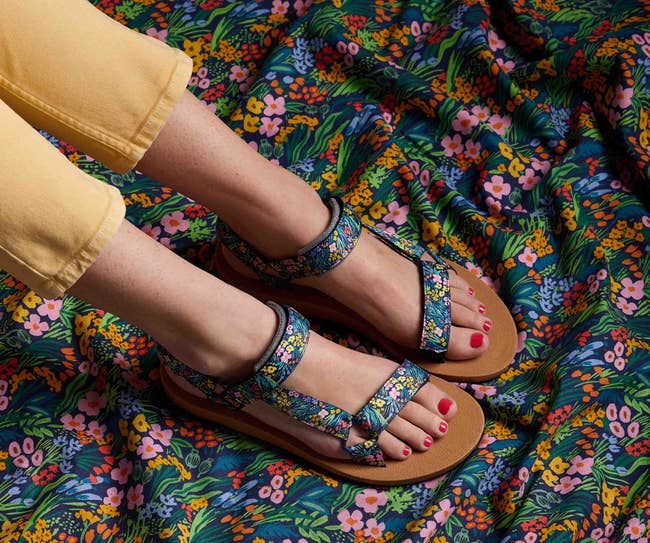model wearing the sandals with floral print all over them