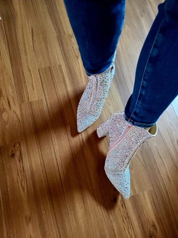 reviewer photo of them posing in silver sparkly booties