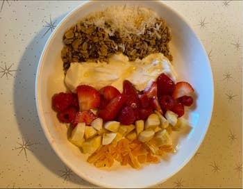 Shallow white bowl plate with fruit and yogurt and granola