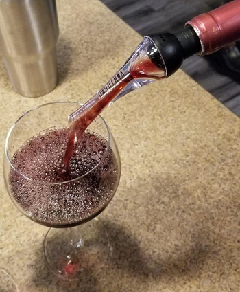 Image of reviewer pouring wine out of aerator 