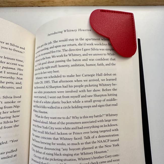 a red heart book mark on the corner of a reviewer's book