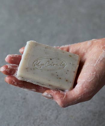 The bar of soap lathered up in a hand