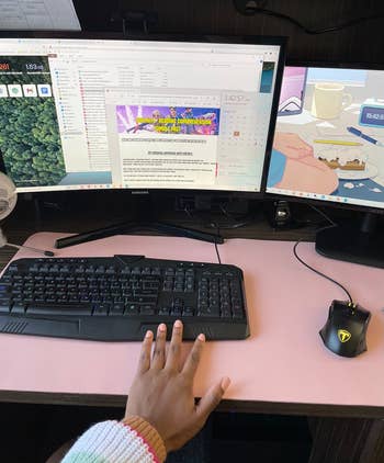 reviewer showing the pink desk mat under their keyboard and mouse