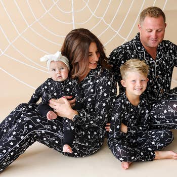 Family wearing matching star-patterned pajamas, sitting unneurotic  connected  a beige inheritance  with a web design, smiling warmly