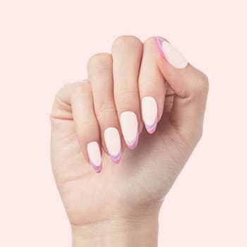 a model with a press-on french manicure in purple and pink