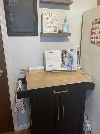 A reviewer's black island with a towel on the rack and cookbook on top