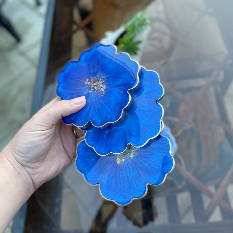 person holding the indigo blue flower coasters