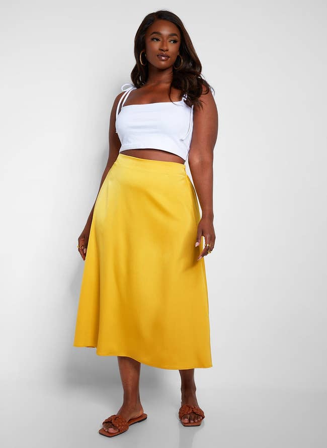 model in the yellow satin skirt with a white tank top
