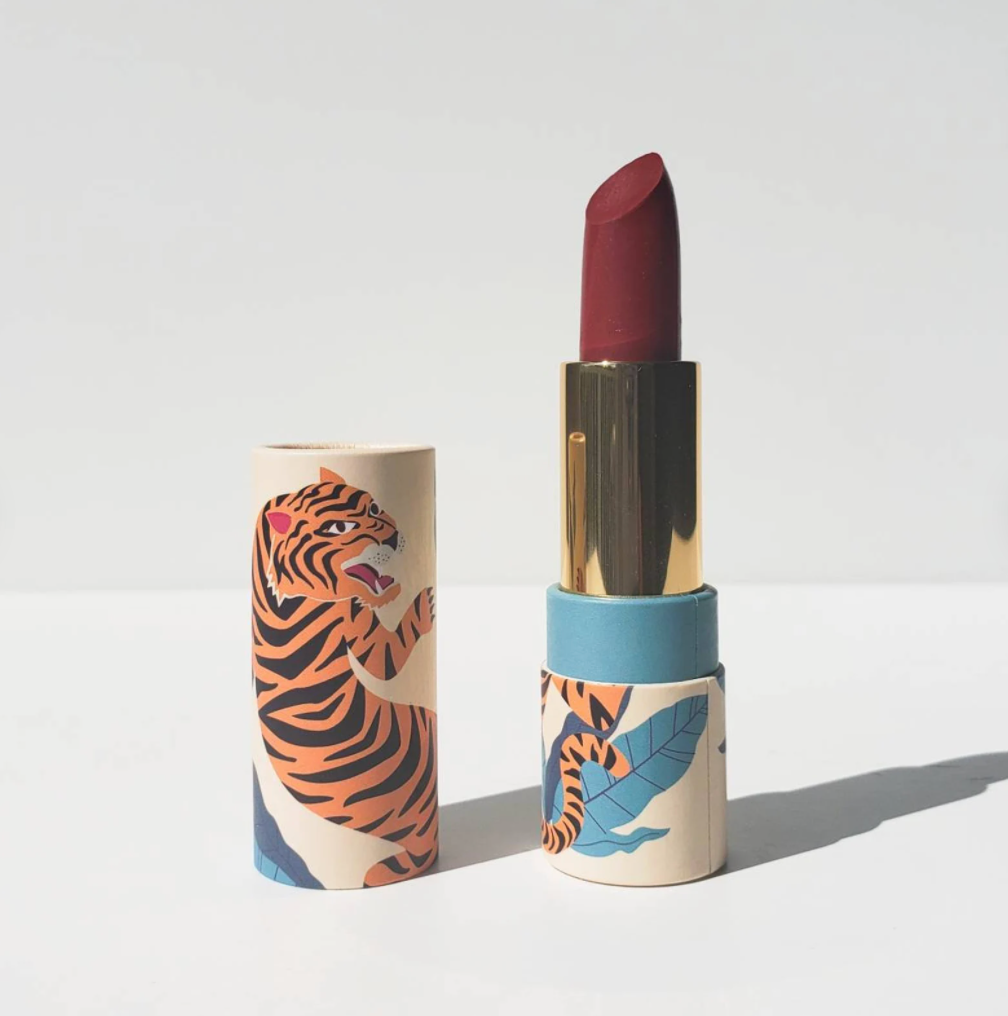 A tube of red lipstick with a vintage tiger illustration on it 