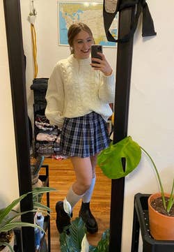 reviewer posing in plaid mini skirt