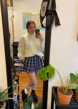 reviewer posing in plaid mini skirt