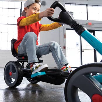 Child model on teal pedal ride-on vehicle