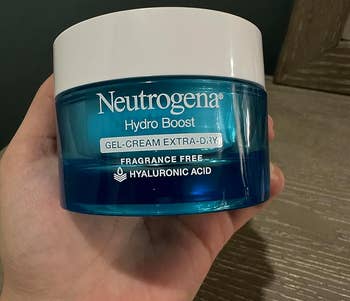 Hand holding a jar of Neutrogena Hydro Boost Gel-Cream for extra-dry skin, fragrance-free with hyaluronic acid