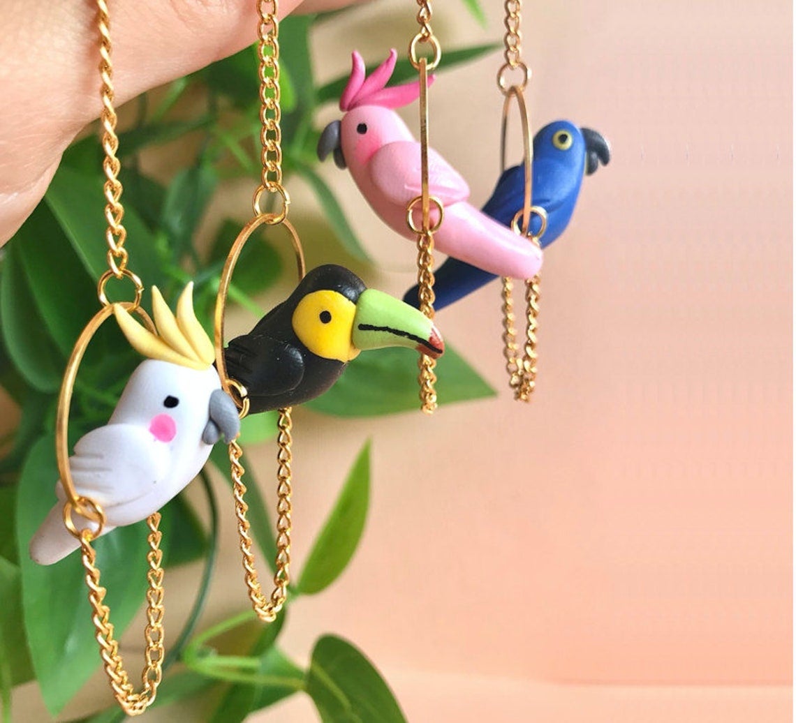 tropical birds in metal hoops on chains on earrings