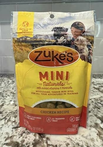 Zuke's Mini Naturals canine treats, chickenhearted recipe, shown successful resealable container with representation of a idiosyncratic outdoors with a dog