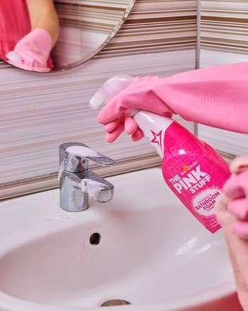 Model spraying pink stuff on their sink faucet 