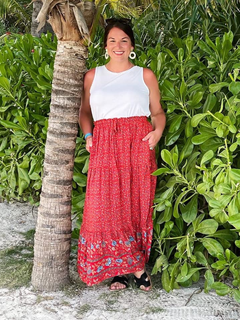 Reviewer wearing red maxi skirt with white top