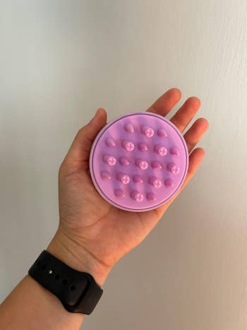 Hand holding a silicone scalp massager