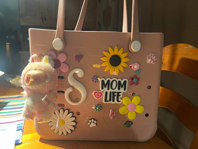 A handbag with colorful flower and paw prints, 
