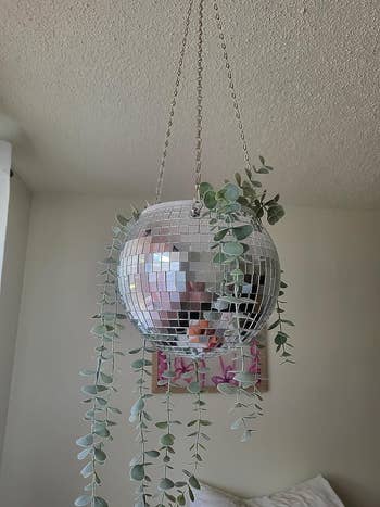 silver disco planter with plant hanging from ceiling