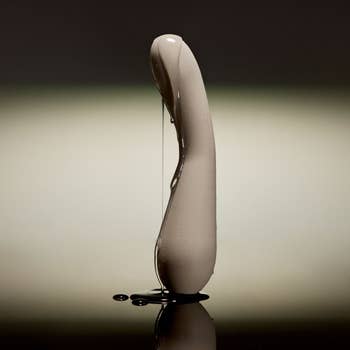 Sleek, modern plan of a curved vibrator lasting upright, with h2o droplets for a glossy finish
