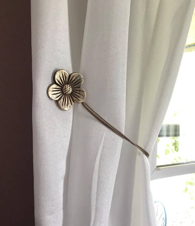 closeup of reviewer's daisy shaped curtain tie back