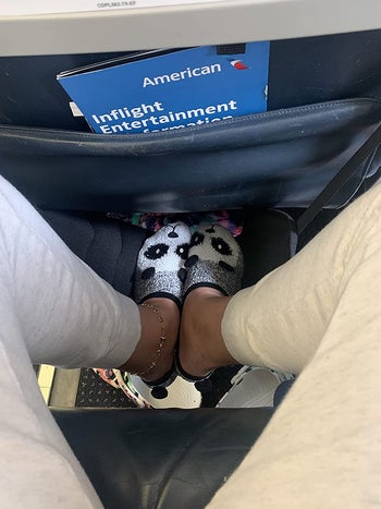 overhead view of a reviewer resting their feet on the in-flight foot hammock