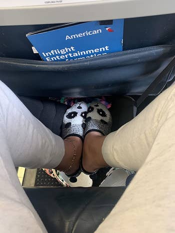 overhead view of a reviewer resting their feet on the in-flight foot hammock