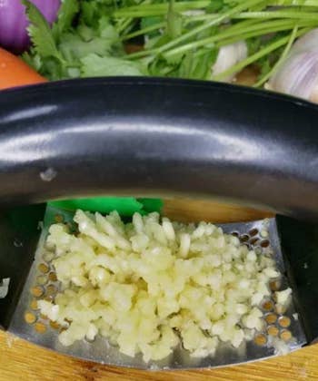 reviewer's garlic press filled with minced garlic 